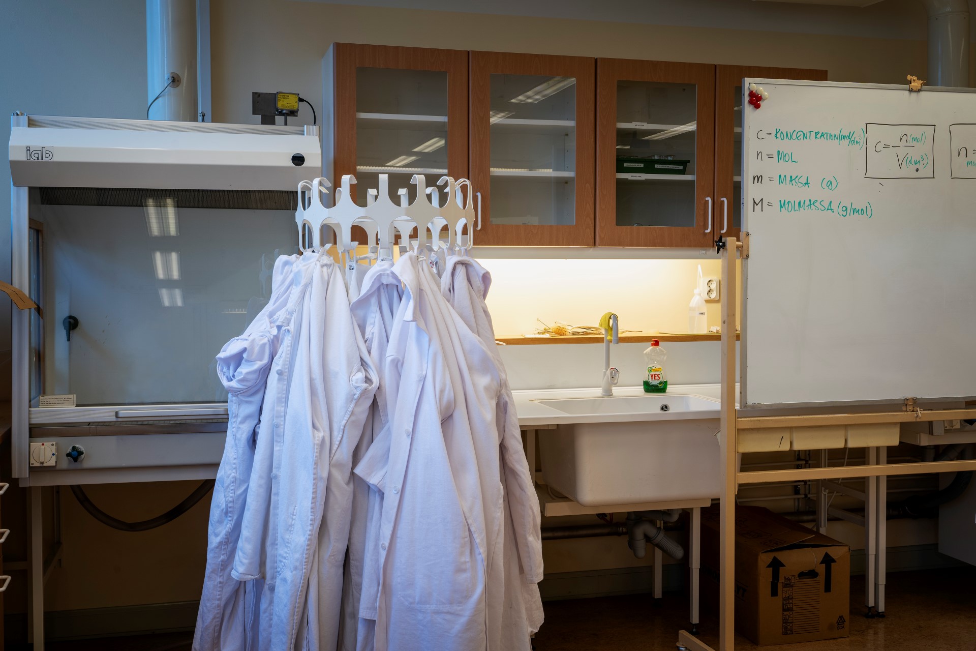 Labbrockar upphängda på krokar i en labbsal på Thorildplans gymnasium